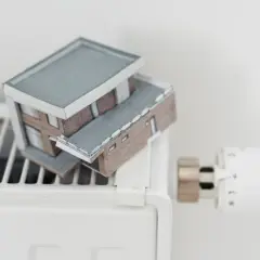 Miniaturowy domek na grzejniku. Czy jest dofinansowanie do gazu ziemnego, by ogrzać taki dom?