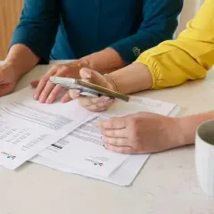 Dwie kobiety analizują dokumenty, być może dotyczące pełnomocnictwa szczególnego.