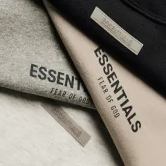 Ubrania marki Essentials, znanej z minimalistycznego stylu i jakości, w odcieniach szarości, beżu i czerni.