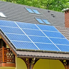 Panele fotowoltaiczne na dachu domu. Czy dofinansowanie do fotowoltaiki jest przychodem? Instalacja zbiera energię słoneczną.