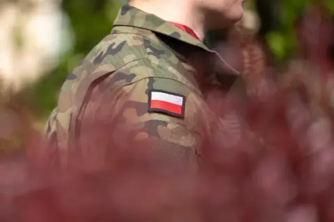 Żołnierz w mundurze moro z polską flagą na ramieniu. Zastanawiasz się, po ilu latach emerytura w wojsku?