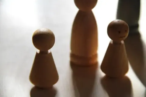 Drewniane pionki symbolizują rodzinę. Ich staż pracy zmarłego a renta rodzinna to ważna kwestia dla bliskich.