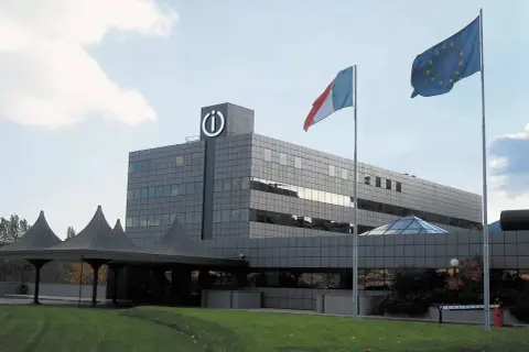Siedziba Indesit, włoskiej firmy AGD. Flagi Włoch i UE powiewają przed nowoczesnym budynkiem.