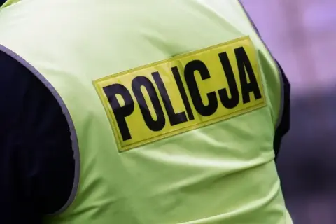 Fragment kamizelki odblaskowej z napisem POLICJA. Może to być widok na służbie lub wspomnienie o emeryturze policyjnej.