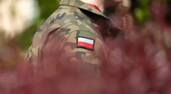 Żołnierz w mundurze moro z polską flagą na ramieniu. Zastanawiasz się, po ilu latach emerytura w wojsku?