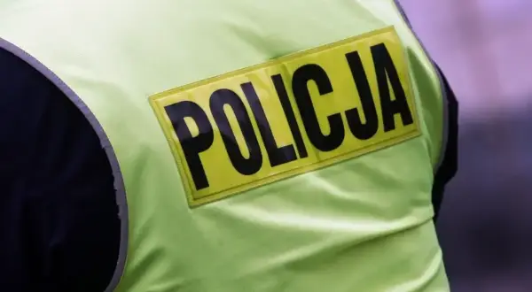 Fragment kamizelki odblaskowej z napisem POLICJA. Może to być widok na służbie lub wspomnienie o emeryturze policyjnej.