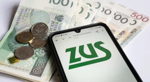 Złotówki i monety na ekranie telefonu z logo ZUS. Sprawdzanie emerytury pomostowej warunki.