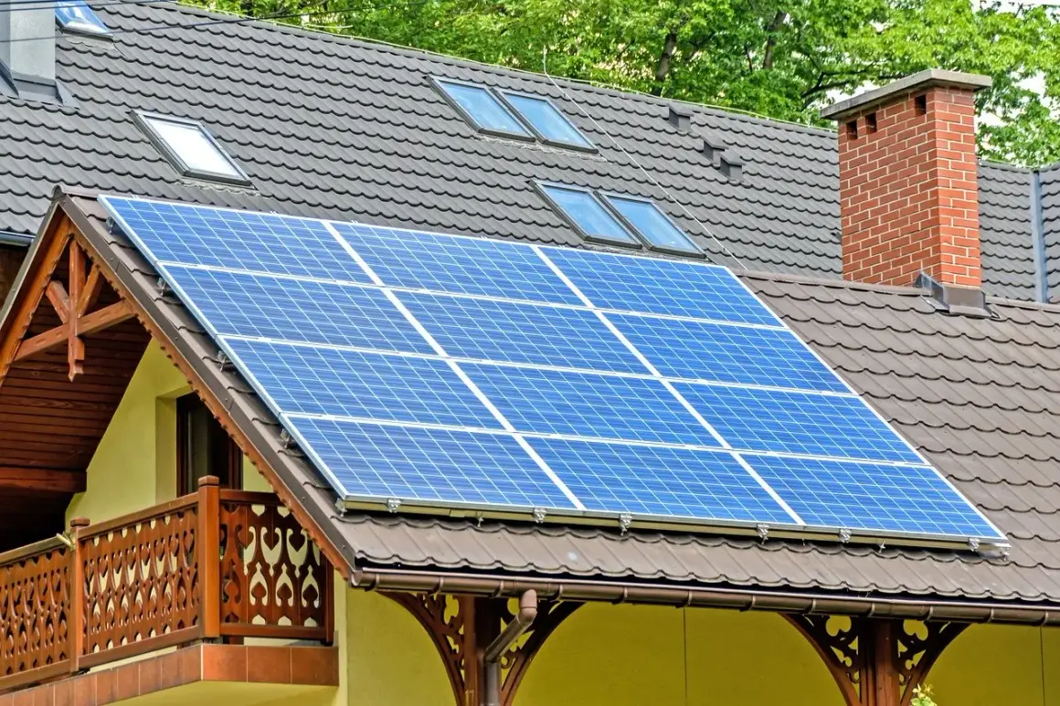 Panele fotowoltaiczne na dachu domu. Czy dofinansowanie do fotowoltaiki jest przychodem? Instalacja zbiera energię słoneczną.