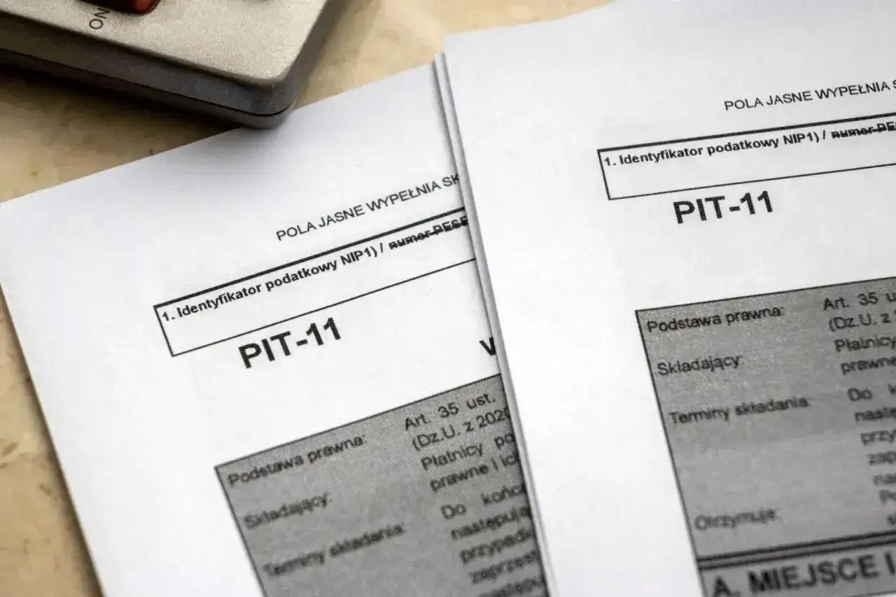 Dwa formularze PIT-11 leżą obok siebie, gotowe do wypełnienia. To ważny krok przed odprawą emerytalną.